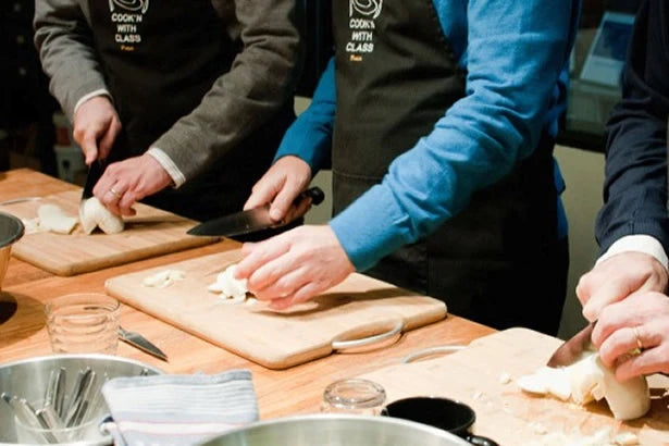 A class prepares food at a cooking class in Paris.